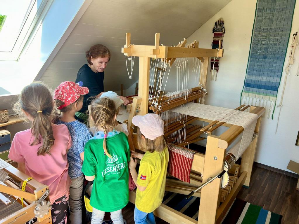 Schulanfänger beim Webstuhl